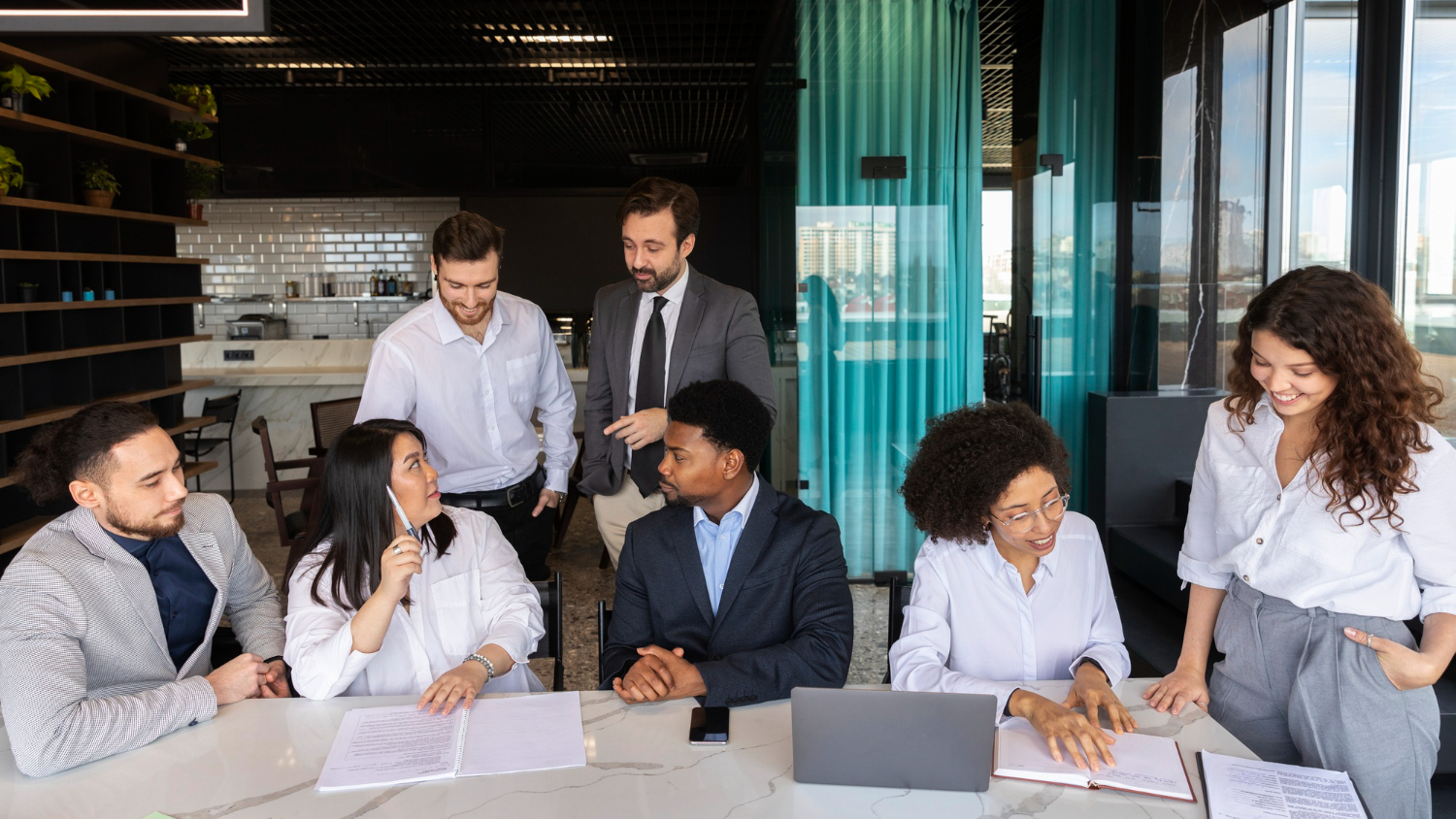 A group of peter and clark employees discuss projects in a boardroom